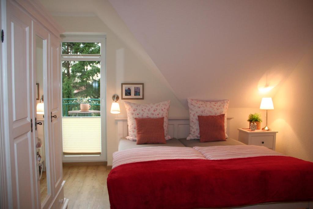 リンテルンにあるWunderschöne Landhauswohnung in Rintelnのベッドルーム1室(赤いシーツ付きのベッド1台、窓付)