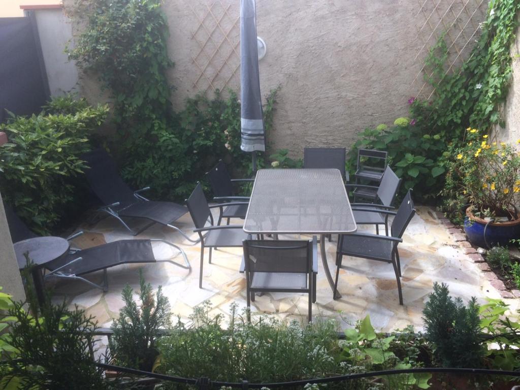 a patio with a table and chairs and plants at Les couleurs de Vauban in Neuf-Brisach