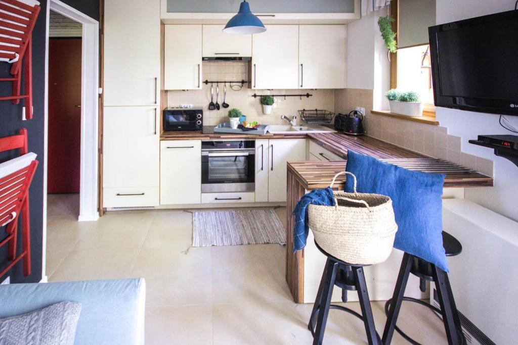 a kitchen with white cabinets and blue stools at Apartament PREMIUM Inga in Poronin