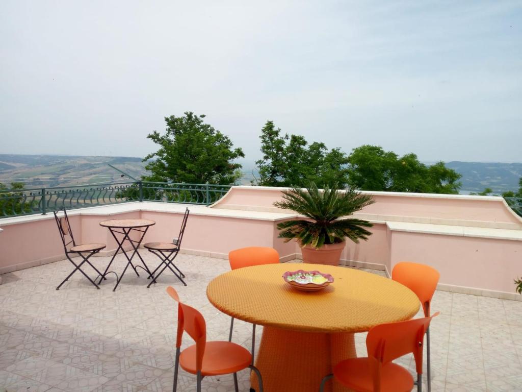 a patio with a table and chairs on a balcony at Le Ginestre in Miglionico