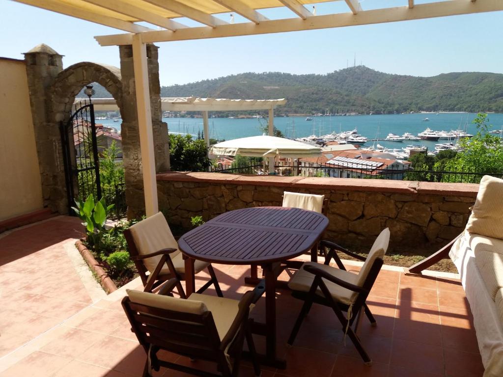 a table and chairs on a patio with a view of the water at Kadyanda Apartments in Fethiye