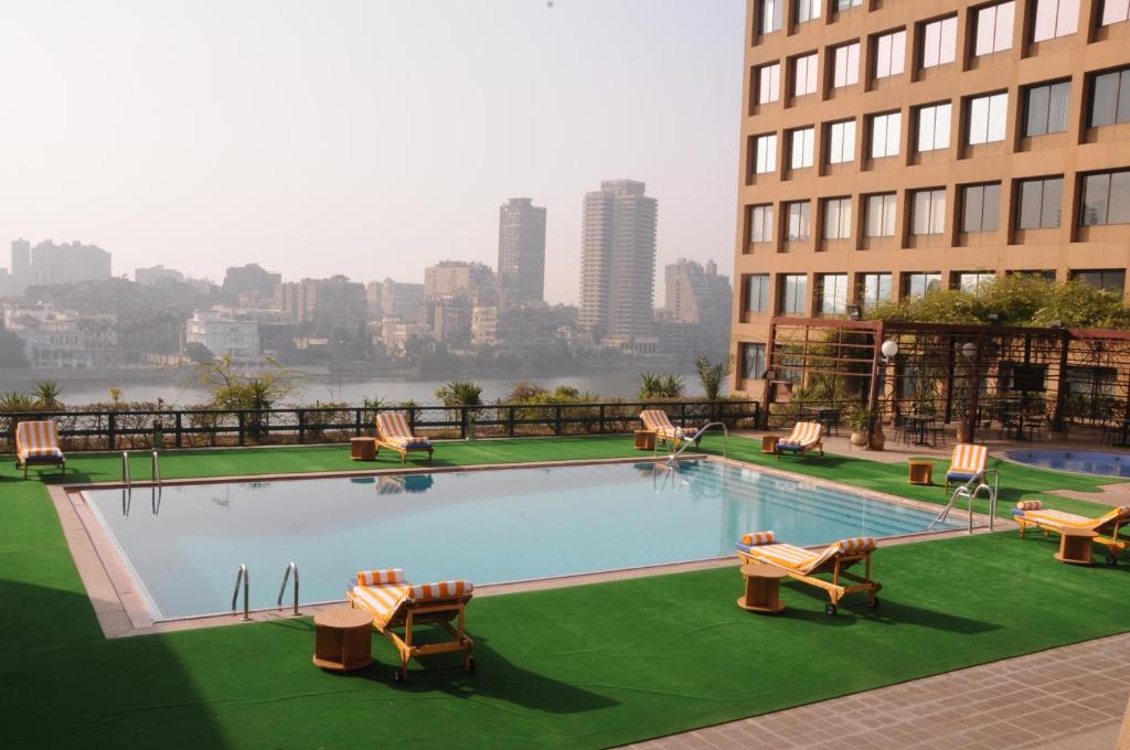 a large swimming pool with chairs and a building at Cairo World Trade Center Hotel & Residences in Cairo
