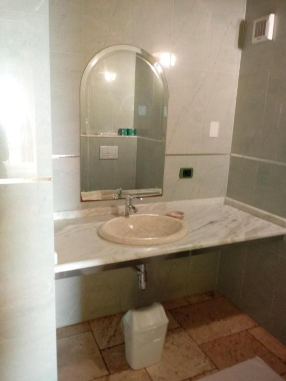 a bathroom with a sink and a mirror and a toilet at Hotel Corsaro Nero in Portu Maga