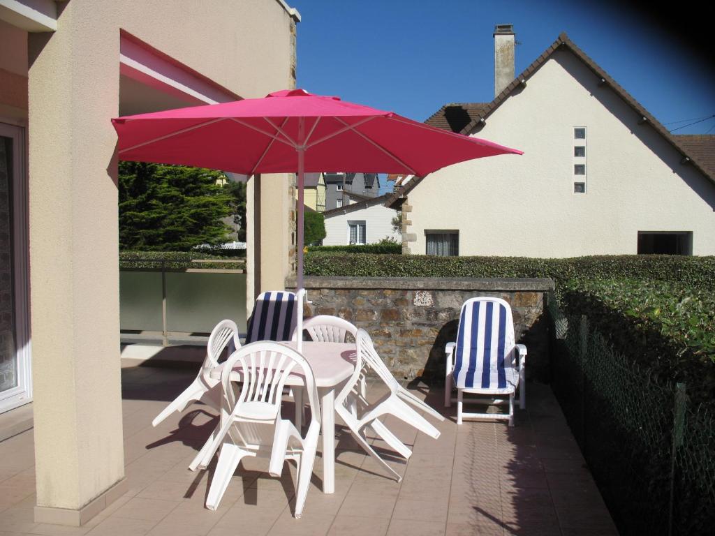 バルヌヴィル・カルトゥレにあるLes terrasses du Châteauの椅子2脚、テーブル1台(赤い傘付)