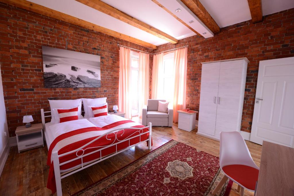 een slaapkamer met een bed en een bakstenen muur bij Willa Starowiejska in Racibórz