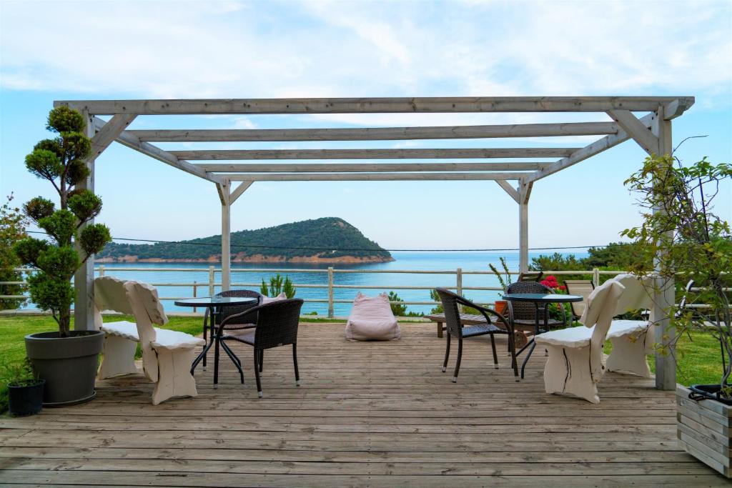 a wooden deck with chairs and a table with a view of the ocean at Agorastos Hotel in Koinyra