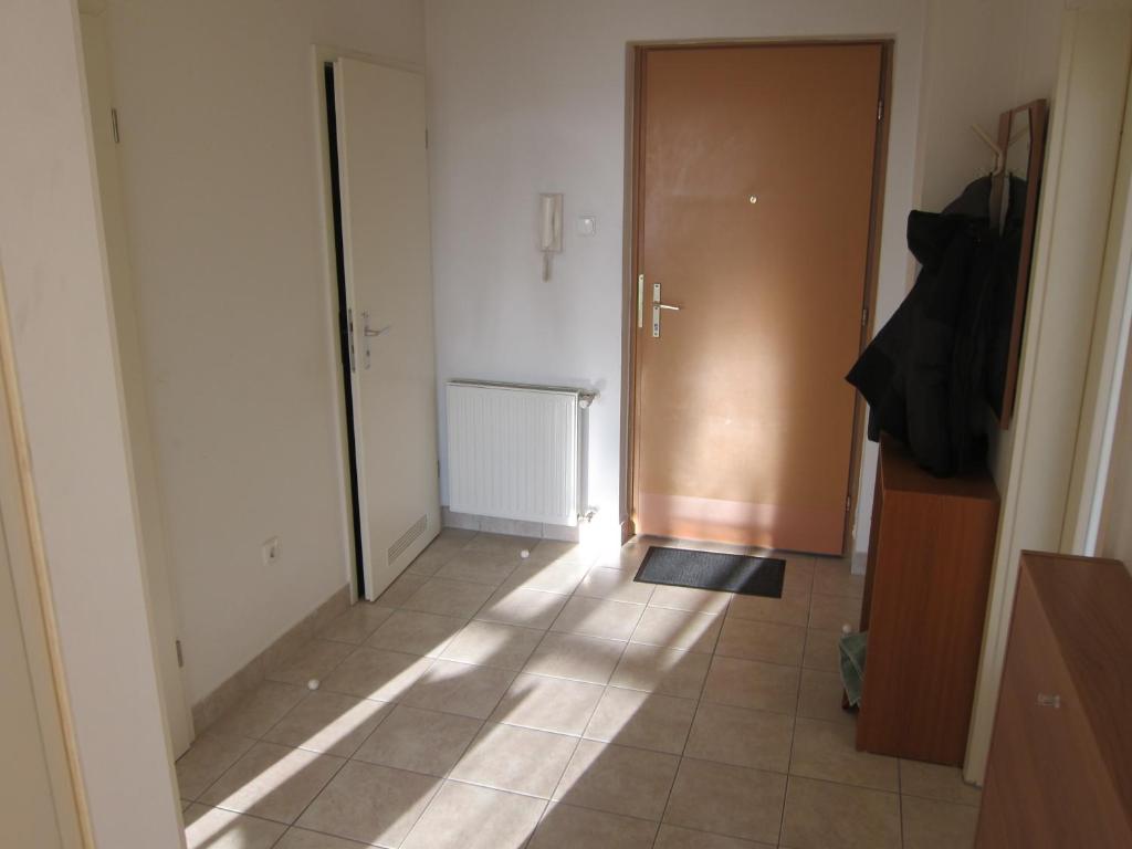 a hallway with a door and a tile floor at Erdélyi vendégház in Sárospatak