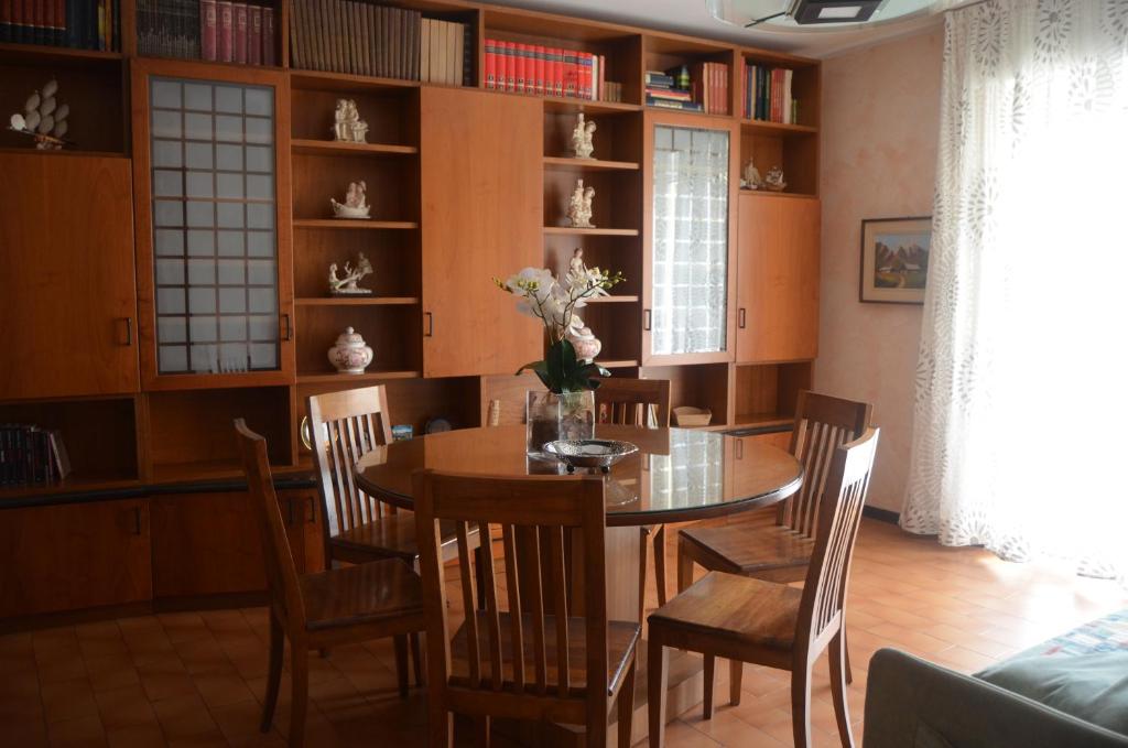 a dining room with a table and chairs and bookshelves at Appartamento Iris in Bellano