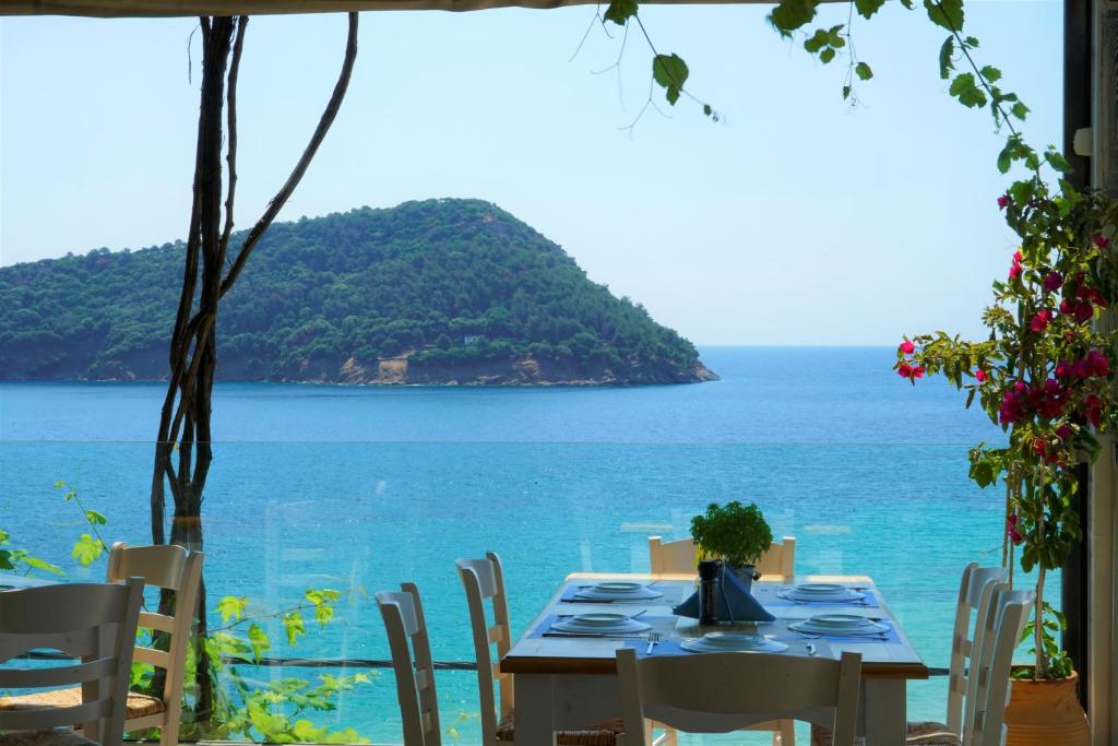 a table with chairs and a view of the ocean at Agorastos Hotel in Koinyra