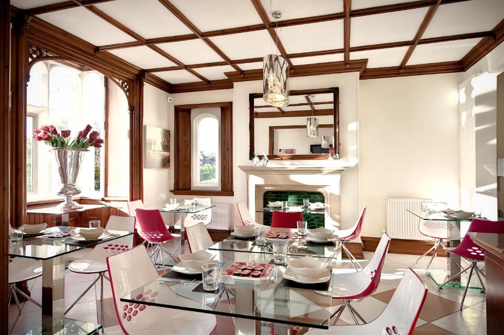 a dining room with a table and chairs and a fireplace at Godalming Hotel Guest House in Godalming