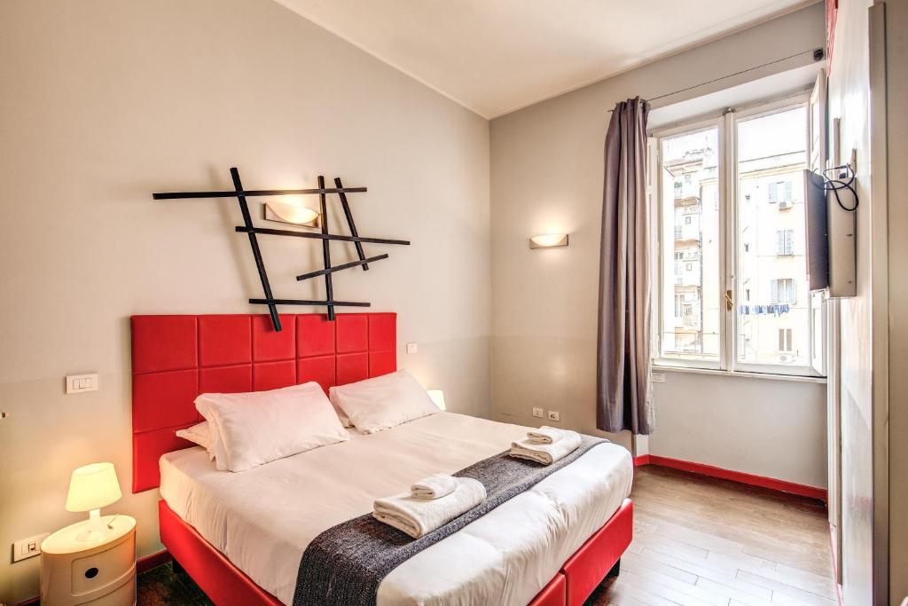 a bedroom with a red bed with towels on it at Milazzo23 in Rome