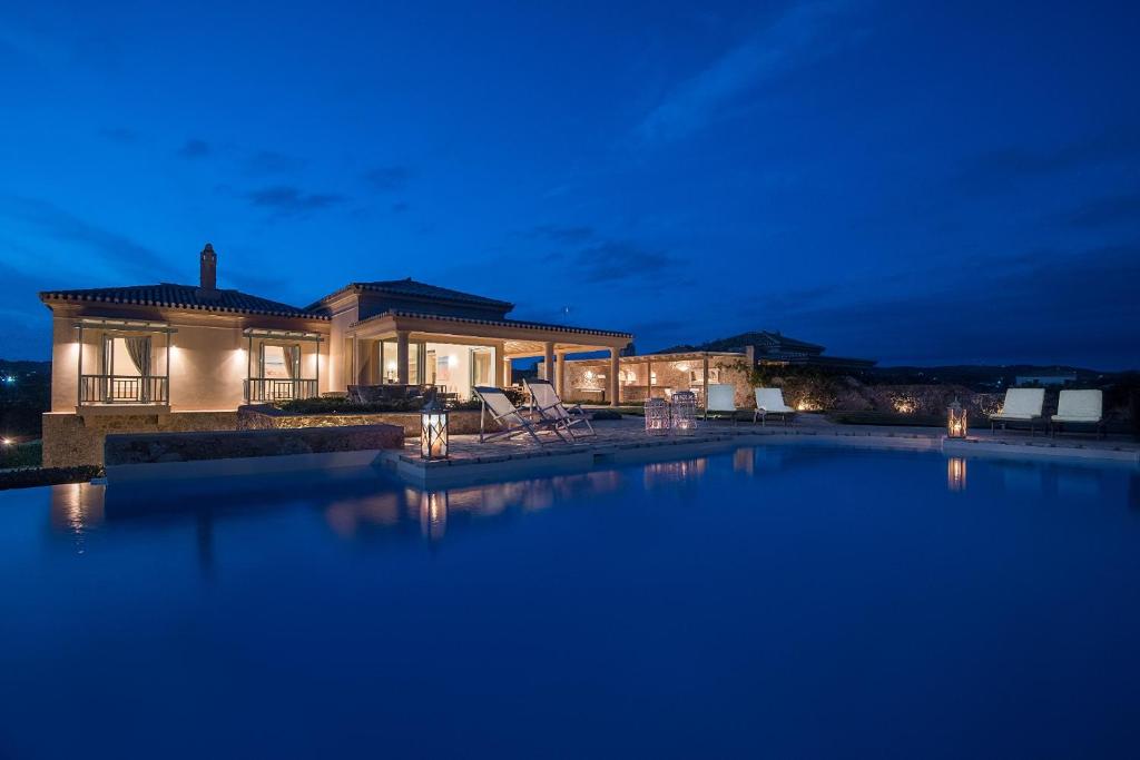 a house with a swimming pool at night at Villa Gold in Porto Heli