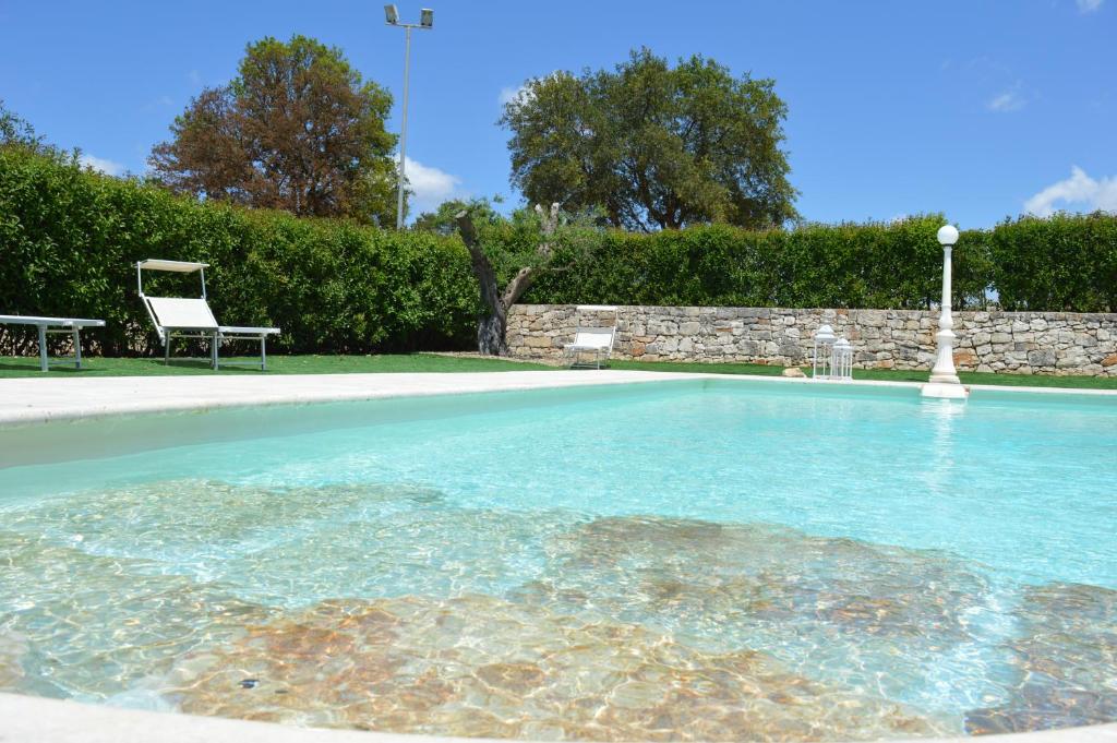 a swimming pool in a yard with a chair at Masseria Paglieroni in Martina Franca