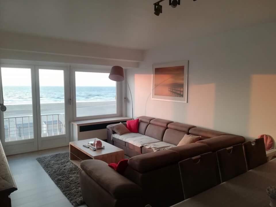 a living room with a couch and a table at appartement zeedijk westende in Middelkerke
