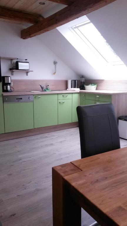 a kitchen with green cabinets and a wooden table at Ferienhof Hering, Inhaber Ina Tharang in Hinterhermsdorf