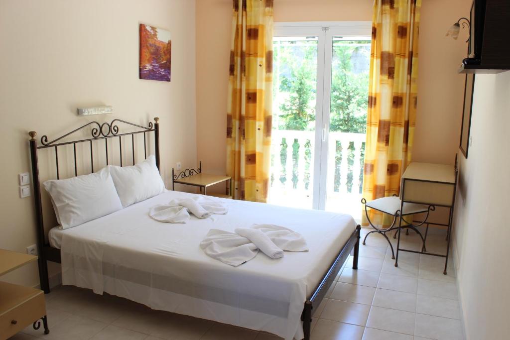 a bedroom with a bed with two towels on it at Turtle Beach Apartment in Marathias