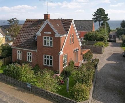 een rood bakstenen huis met een tuin ervoor bij My Home in Spodsbjerg