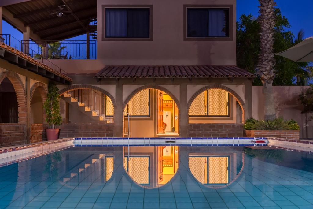 a house with a swimming pool in front of a house at Loreto Playa Boutique Hotel in Loreto
