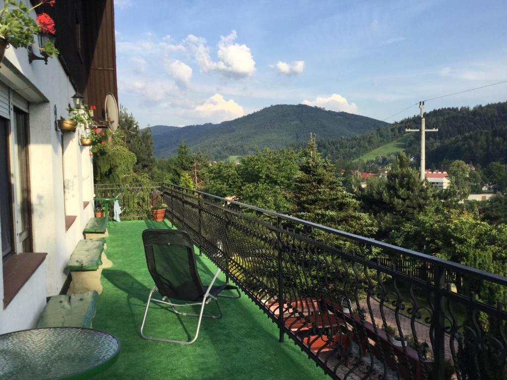 a balcony with a table and chairs and mountains at Na Markówce in Brenna
