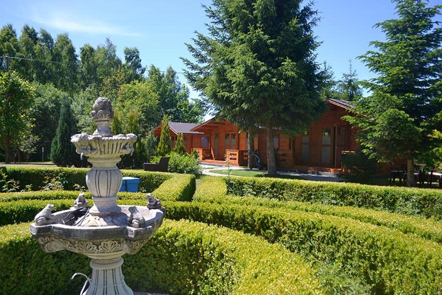 a statue in the middle of a garden at Domki pod orzechem in Kołczewo