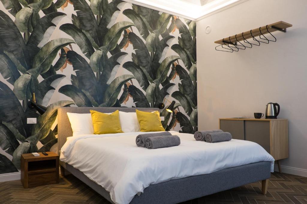 a bedroom with a large bed with a tropical wallpaper at The Gallery 42 Guest House in Florence