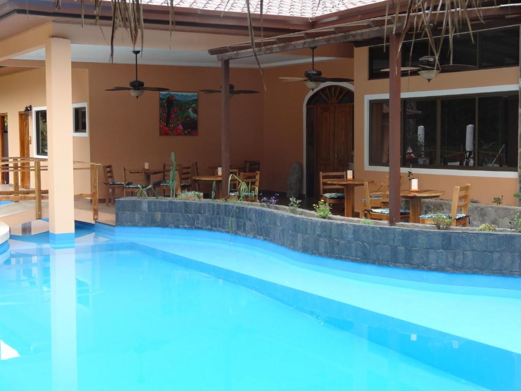 a swimming pool in a villa with a restaurant at Hotel-Boutique Patampa in David