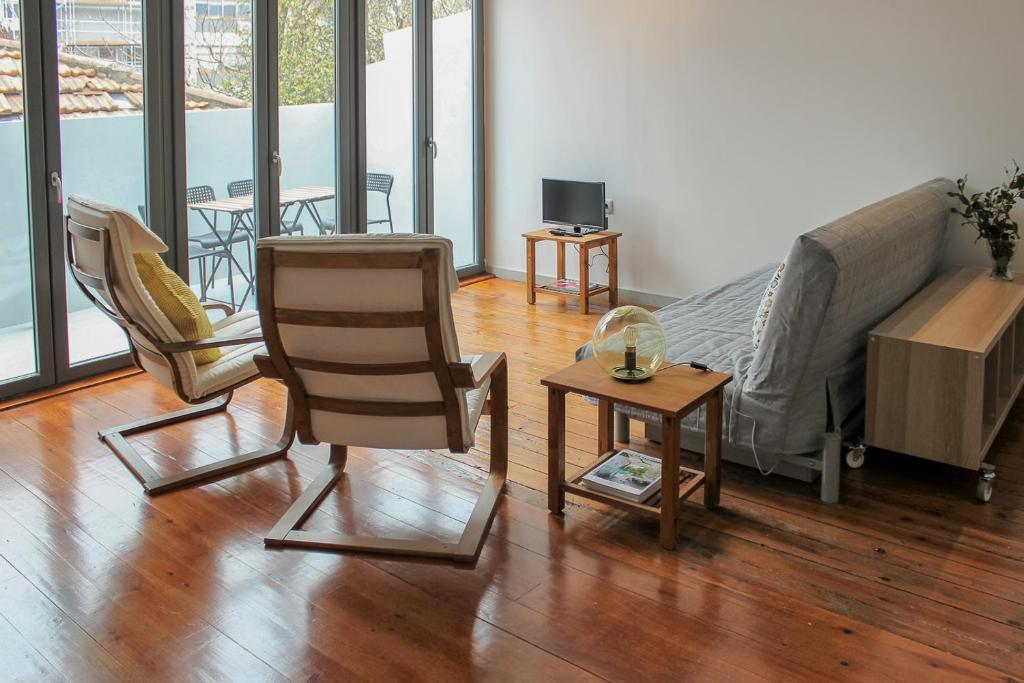 sala de estar con cama, sillas y mesa en Bonjardim Flats - T2 com Varanda, en Oporto