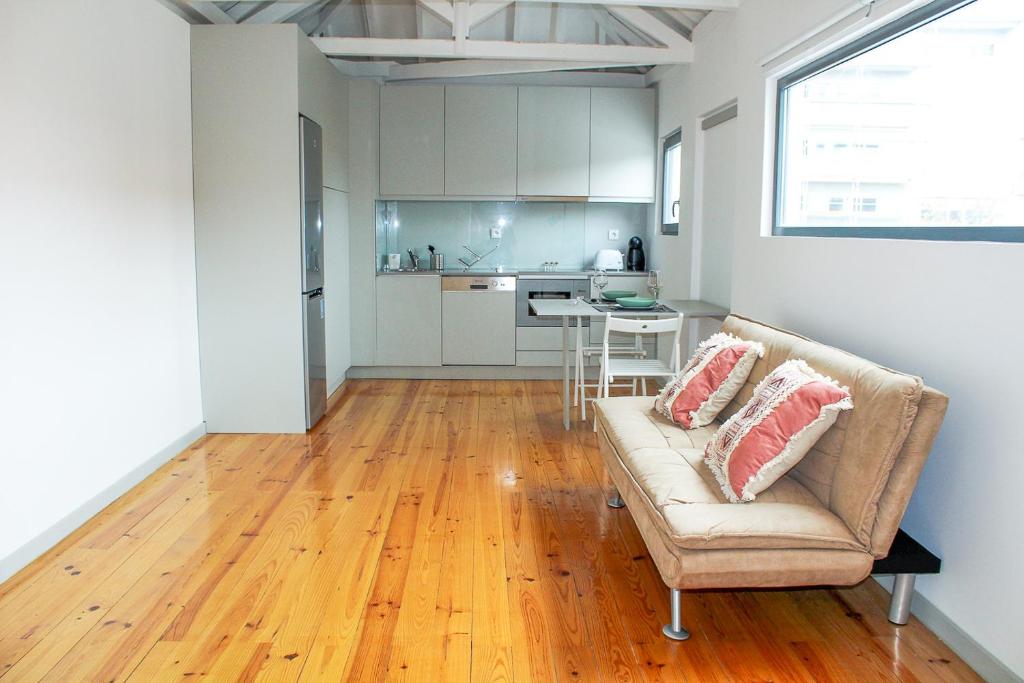 uma sala de estar com um sofá e uma cozinha em Bonjardim Flats - T1 + 1 com terraço no Porto