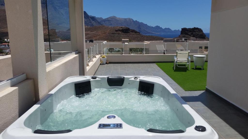 a jacuzzi tub on a balcony with a view at Él Rome Duplex in Agaete