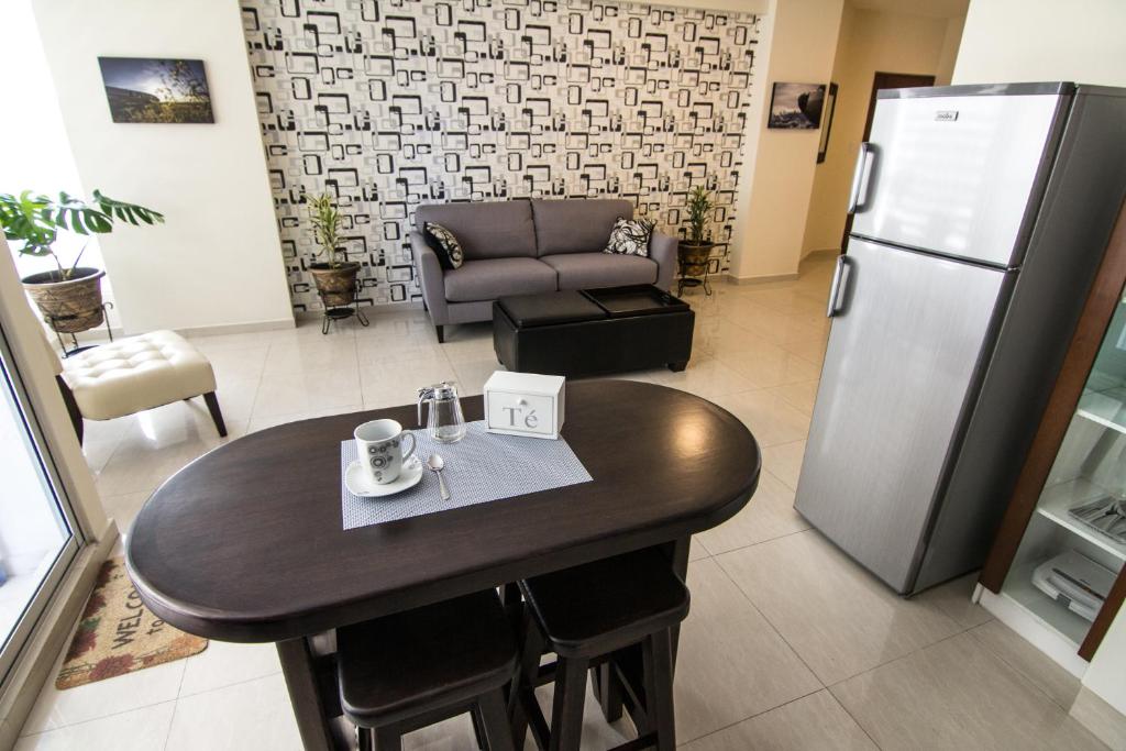 Il comprend une cuisine équipée d'une table et d'un réfrigérateur. dans l'établissement Apartamento Familiar Ideal, à Cochabamba