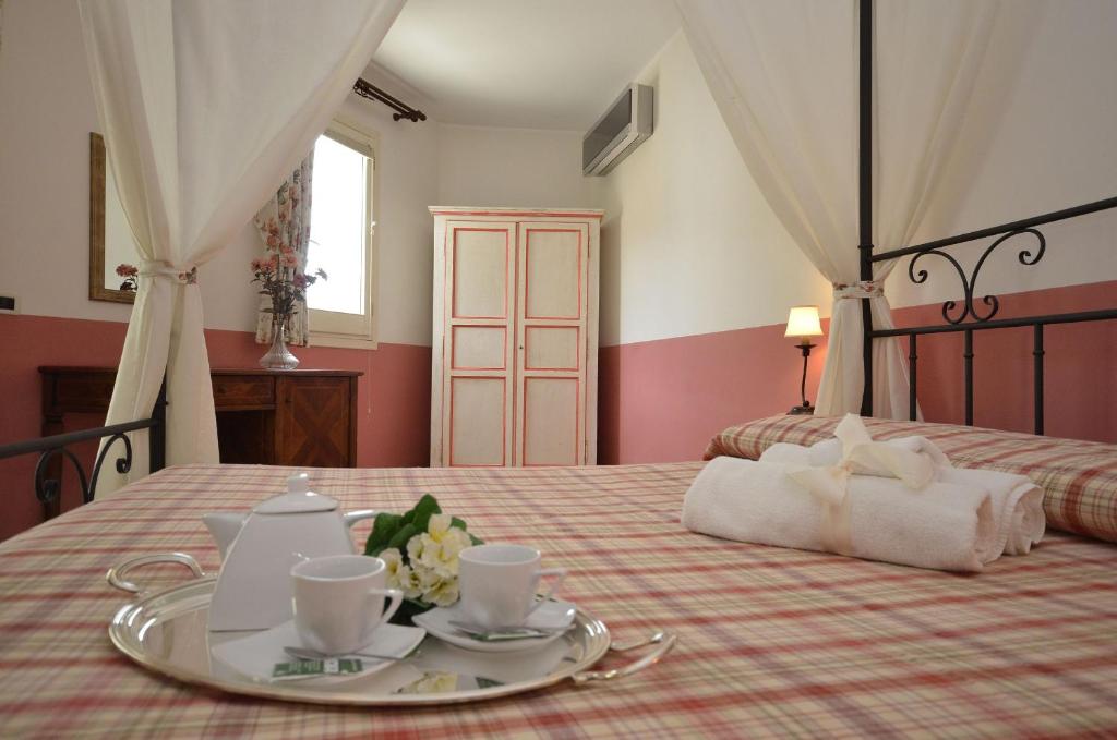 カステッルッツォにあるCatarin Comfort Roomsのベッドルーム1室(ベッド1台、トレイ、カップ、ソーサー付)