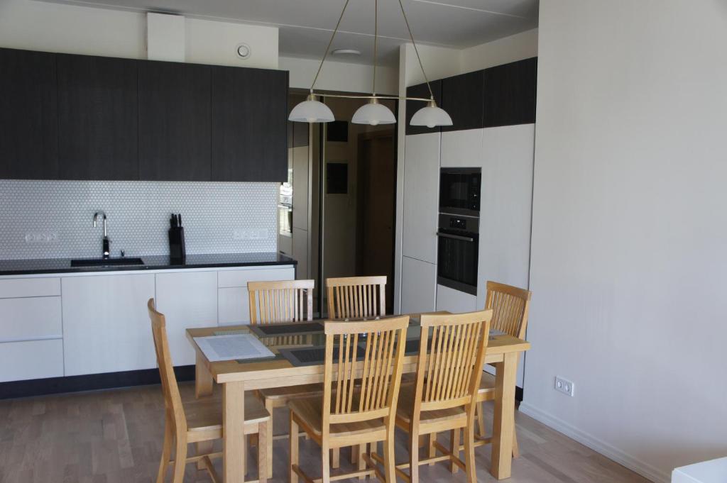 a kitchen with a dining room table and chairs at Kotkapoja Apartment in Kuressaare