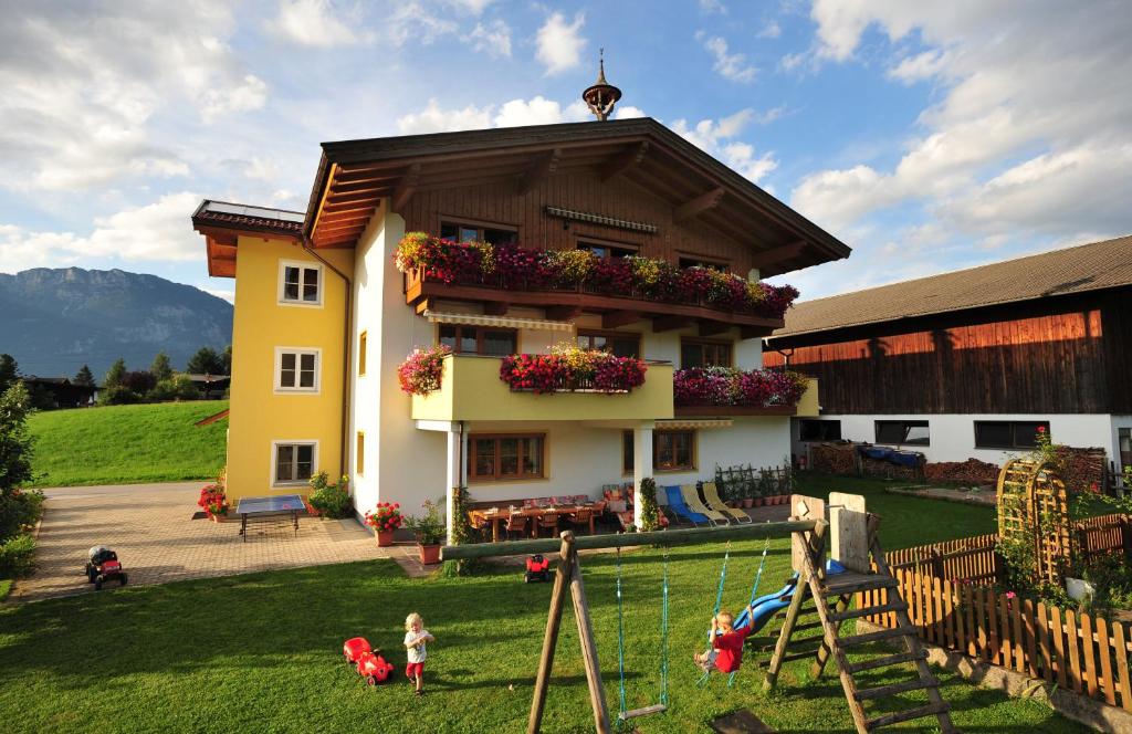 una casa con niños jugando en el patio en Waldschönau, en Kirchbichl