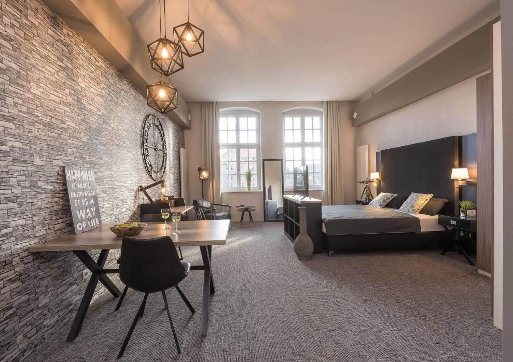 - une chambre avec un lit, un bureau et un canapé dans l'établissement Boardinghouse Emden, à Emden