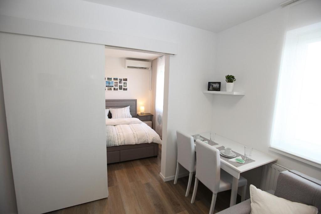 a bedroom with a bed and a table and chairs at Elegant central Apt Maribor w/Parking in Maribor