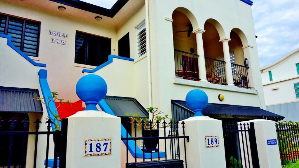 a house with a gate with blue statues on it at Floriana Villas in Cairns