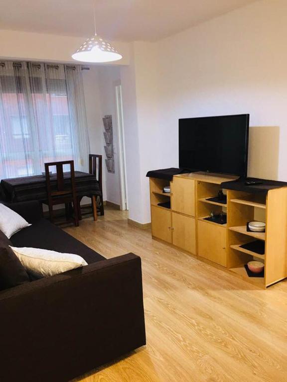 a living room with a couch and a flat screen tv at Vedruna Imperial Tarraco in Tarragona