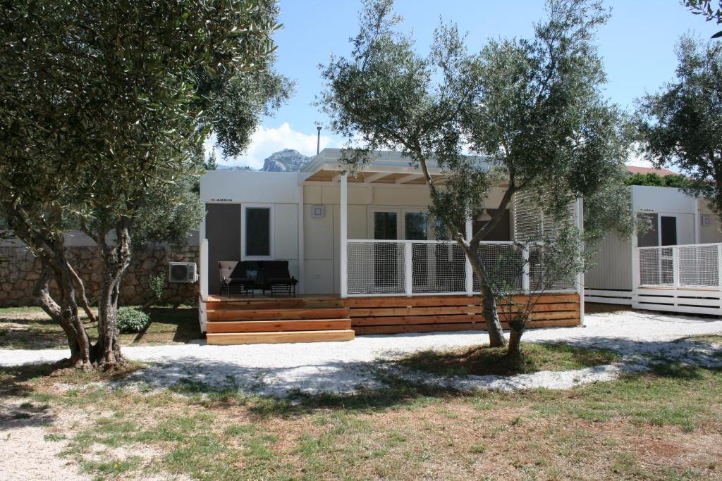 una casa con árboles delante de ella en Mobile Homes Katinka, Starigrad Paklenica, Croatia, en Starigrad-Paklenica