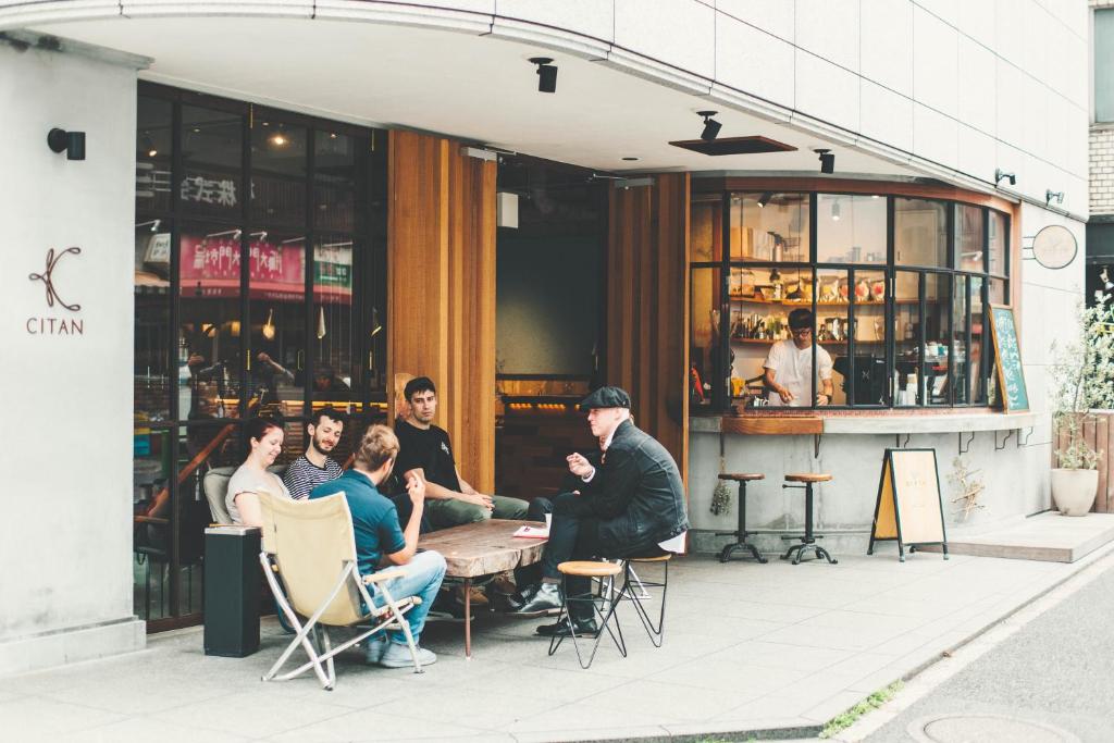 a group of people sitting at a table outside a restaurant at CITAN Hostel in Tokyo