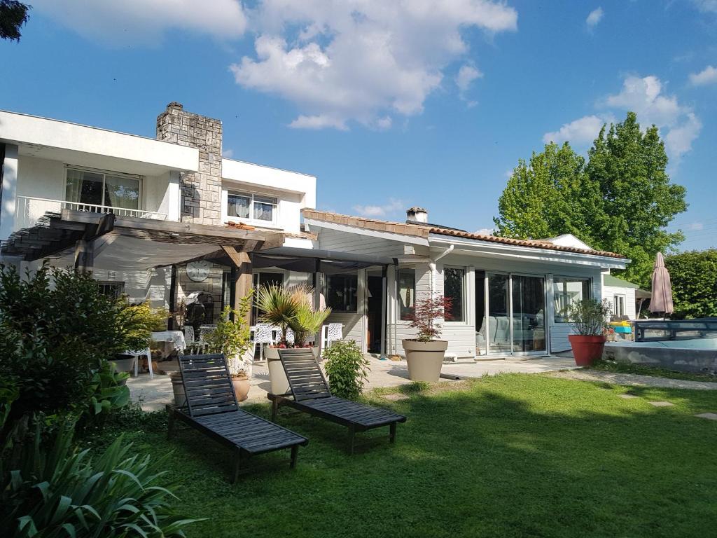 una casa con tres sillas en un patio en Maison Lucilda, en Pessac