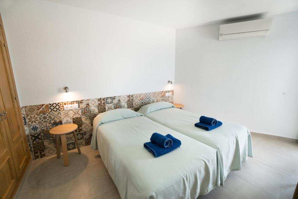 twee bedden in een kamer met blauwe handdoeken erop bij Torresol 408 Menyber in Nerja