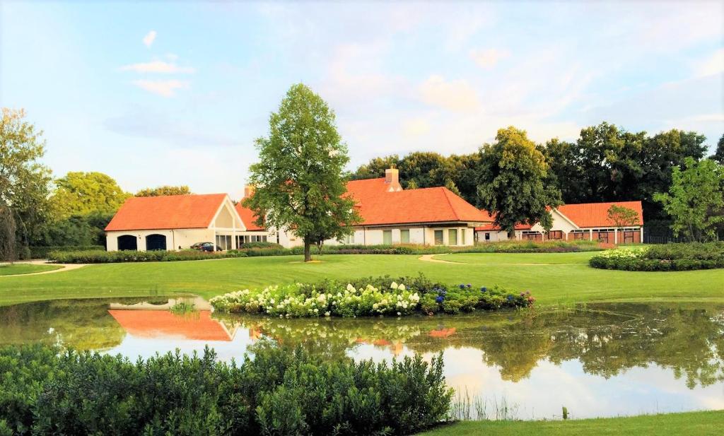 ヴェールトにあるVilla Kempen-Broekの池のあるゴルフ場の家