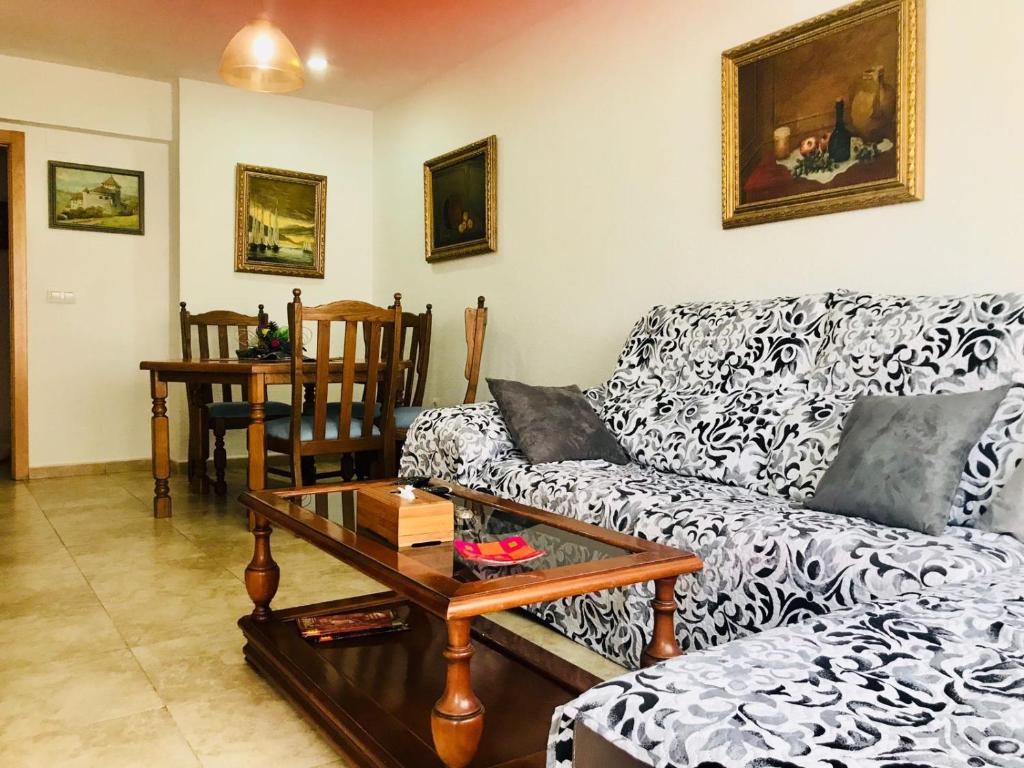 a living room with a couch and a table at Habitaciones privadas Alicante centro in Alicante