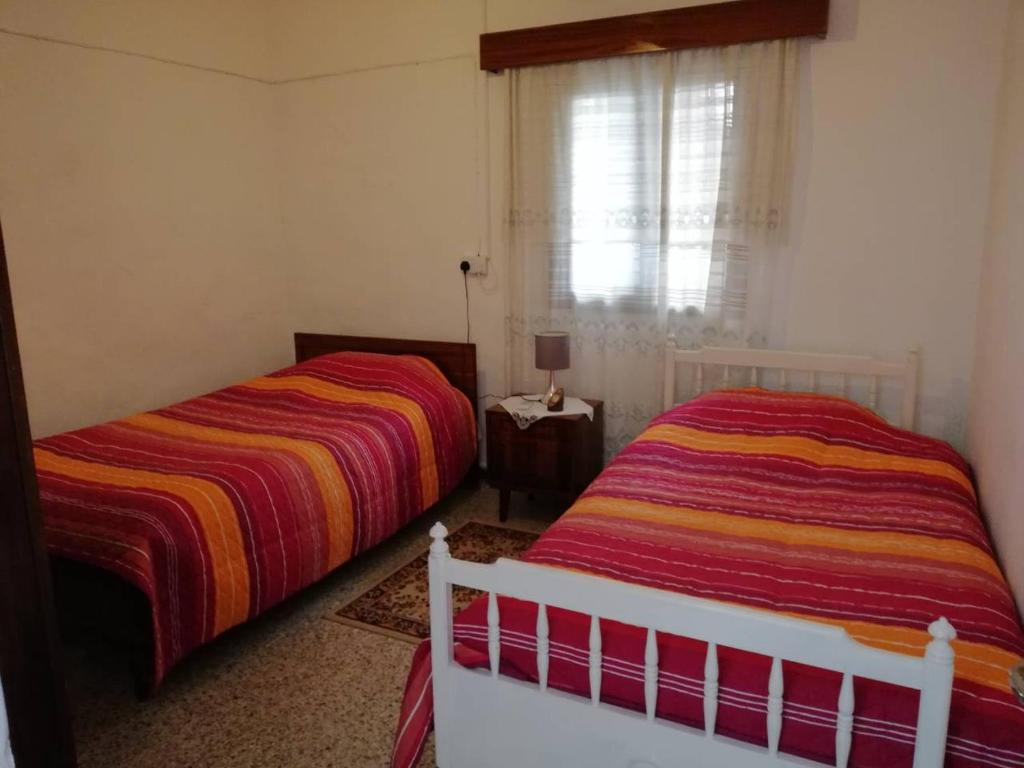 1 dormitorio con 2 camas y ventana en Christos House, en Kakopetria