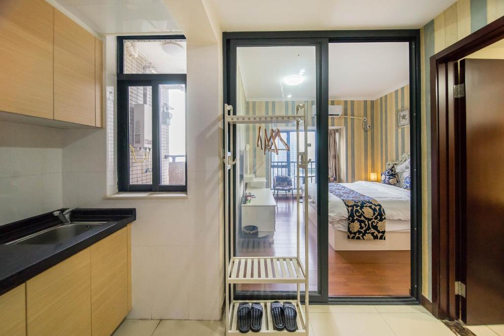 a kitchen with a sink and a room with a bed at Xing Yu Legend Service Apartment Canton Fair Branch in Guangzhou