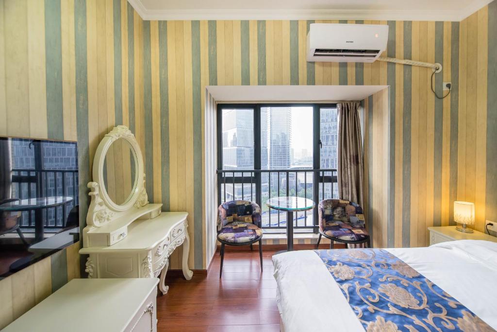 a hotel room with a bed and a mirror and a balcony at Xing Yu Legend Service Apartment Canton Fair Branch in Guangzhou