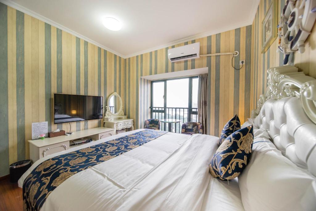 a bedroom with a large bed and a television at Xing Yu Legend Service Apartment Canton Fair Branch in Guangzhou