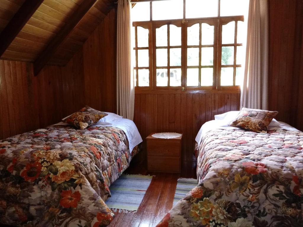 1 dormitorio con 2 camas y ventana en La Cabaña de Noa, en Oxapampa