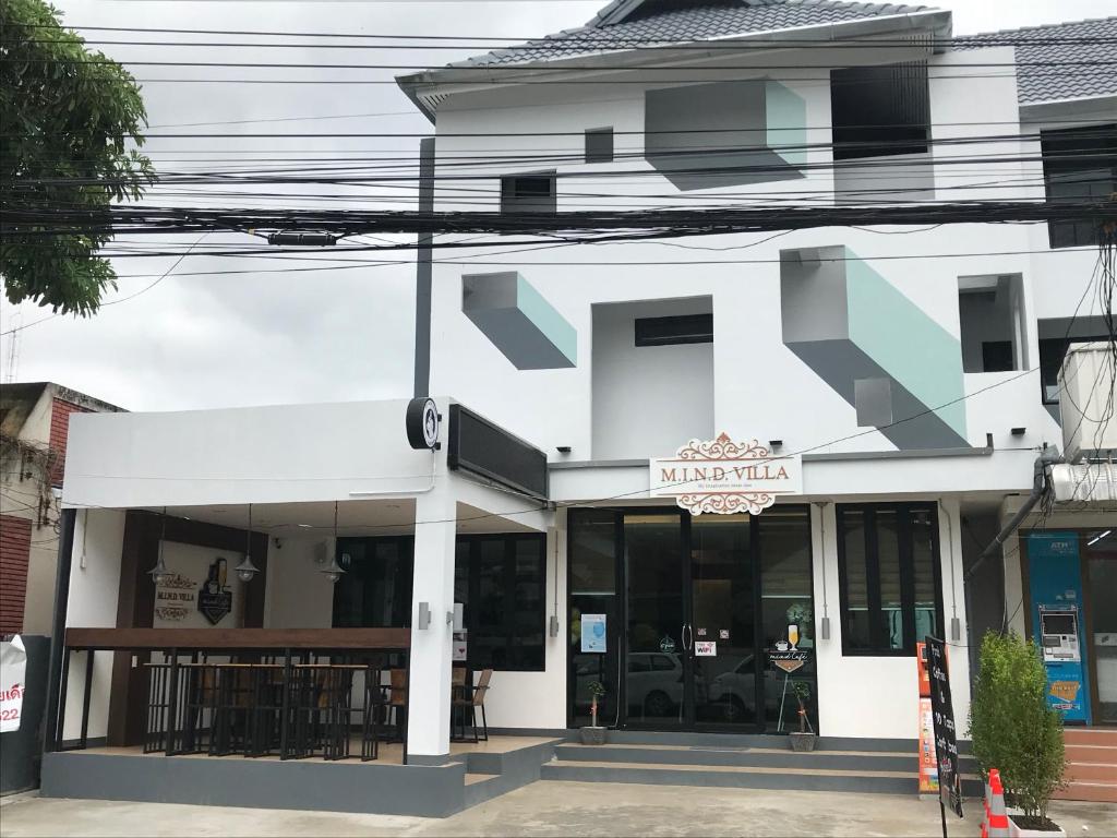 a white building with a sign for a restaurant at M.I.N.D. Villa in Chiang Mai