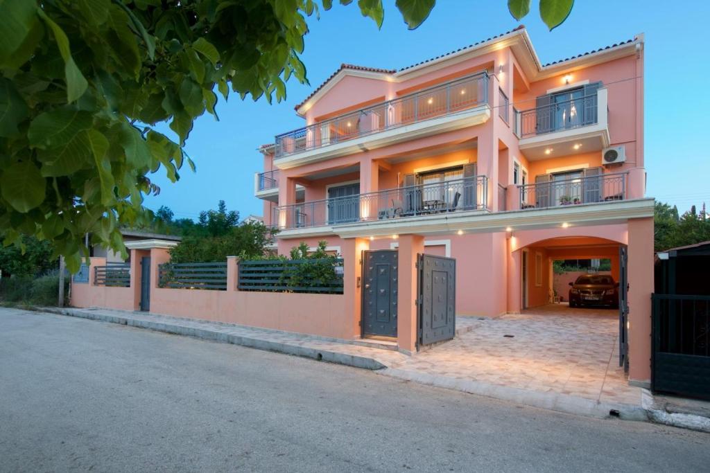 a large pink house with a driveway at K for Kefalonia in Karavomylos